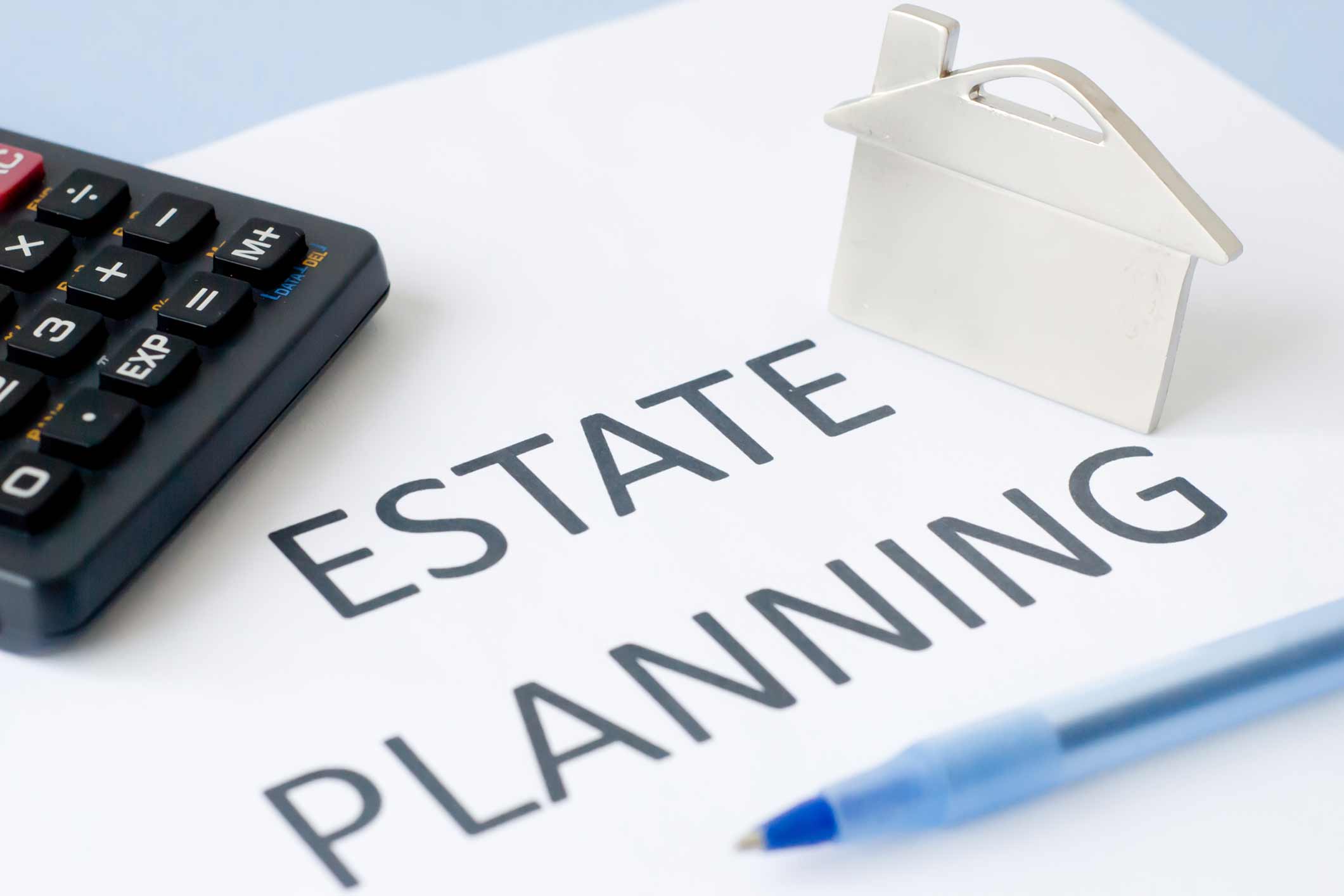 An estate planning document with a calculator and a house.