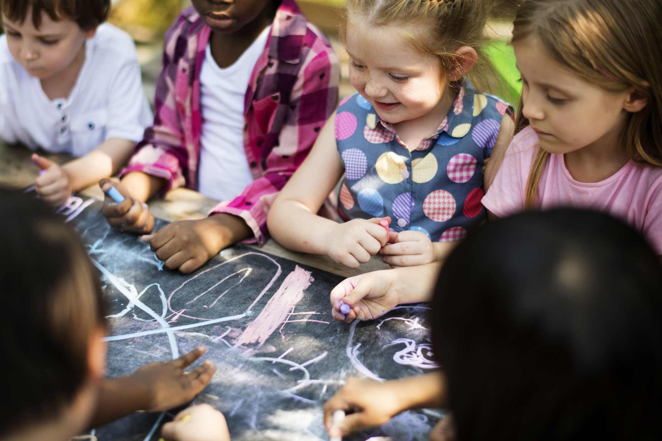 A group of children drawing on a chalkboard.