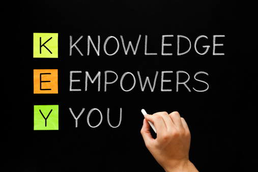 A person writing the word knowledge empowers you on a blackboard.