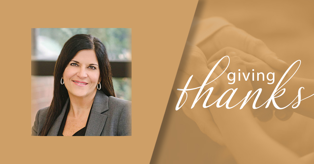 Giving thanks with a woman in front of a brown background.