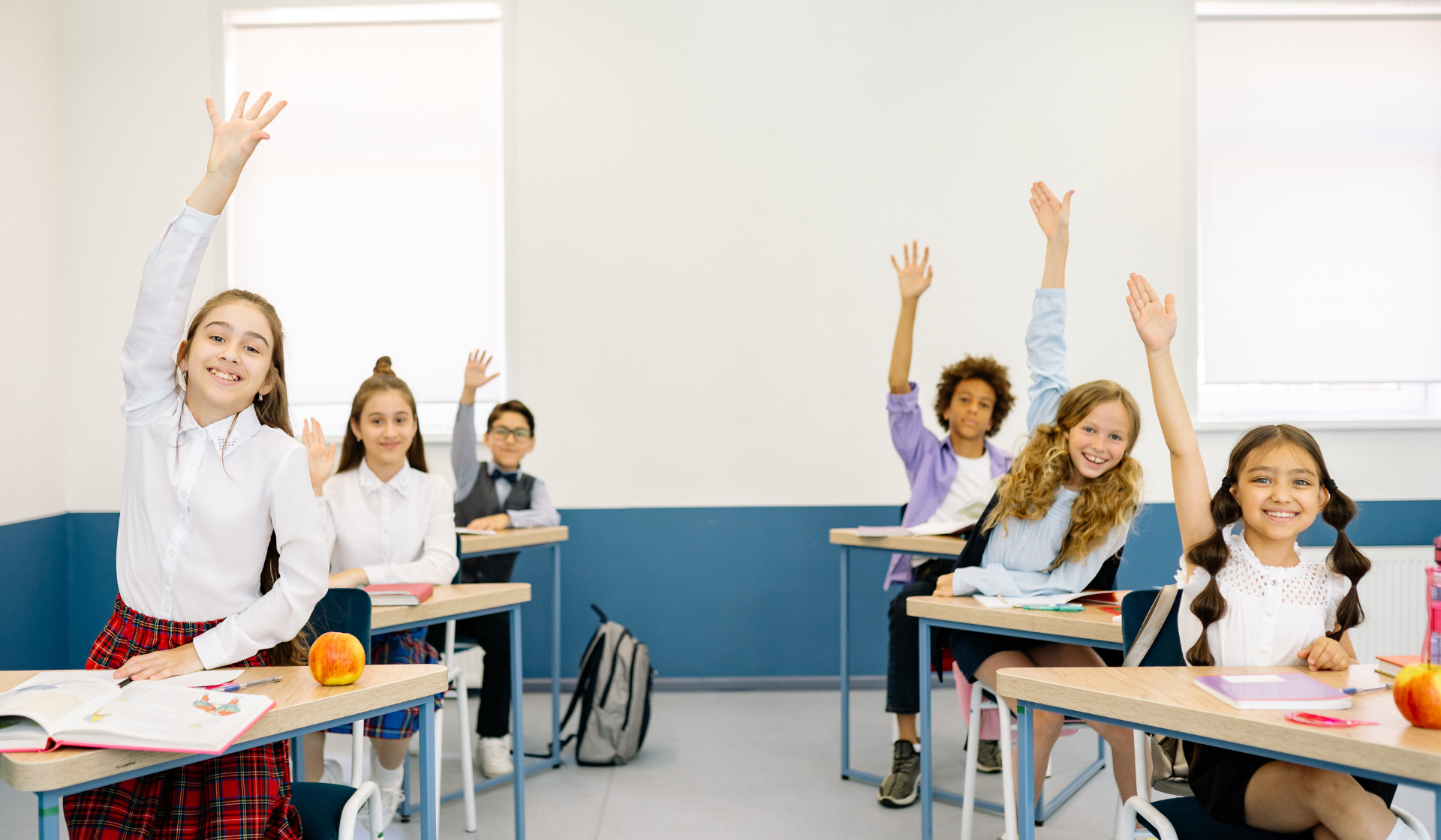 children in school raising their hands